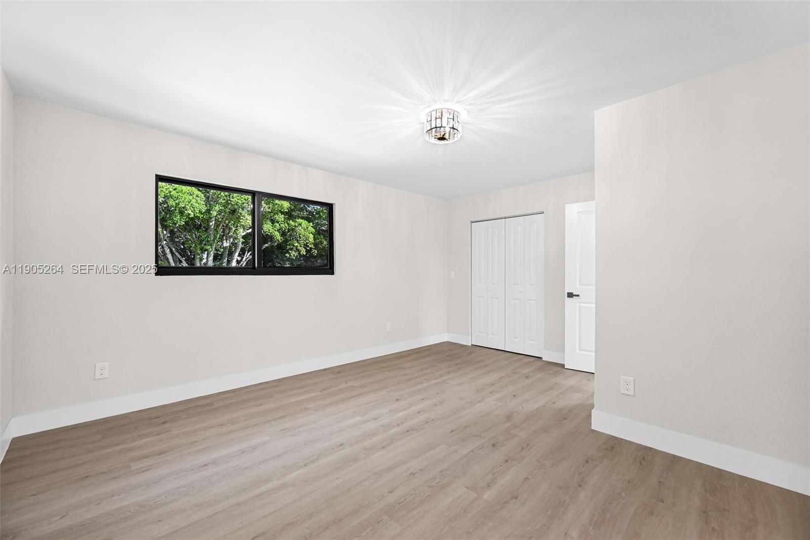 10823 Southwest 147th Court Miami, FL 33196 - Photo 58 of 100 an empty room with wooden floor ceiling fan and windows