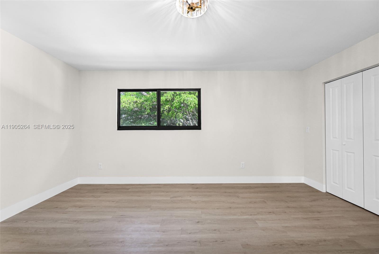 10823 Southwest 147th Court Miami, FL 33196 - Photo 59 of 100 a view of an empty room with wooden floor and a window