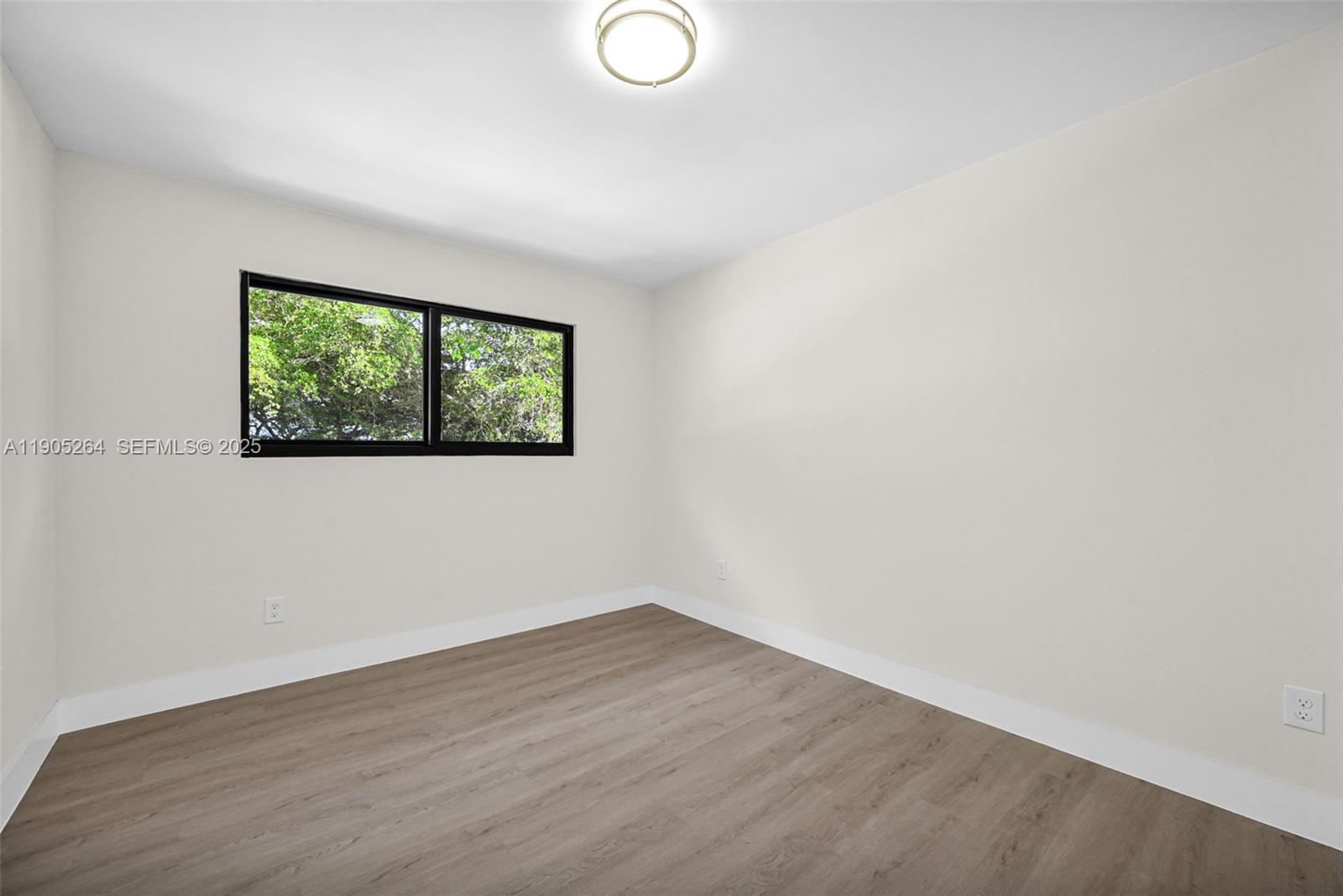 10823 Southwest 147th Court Miami, FL 33196 - Photo 65 of 100 an empty room with wooden floor and window
