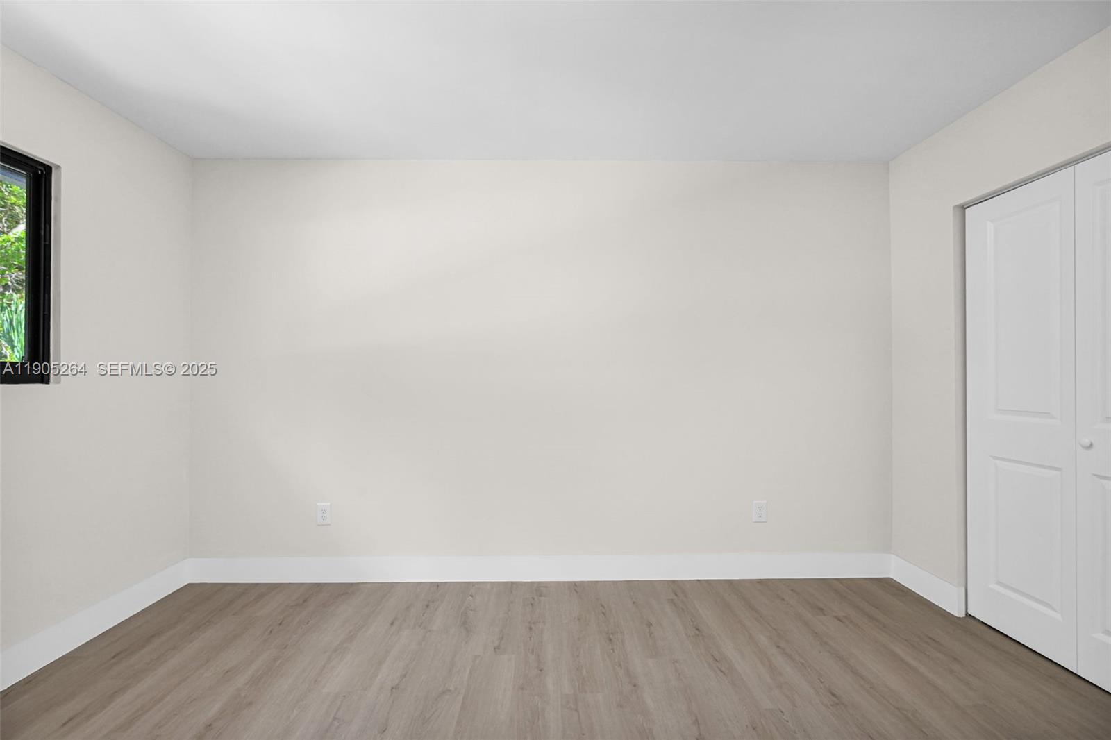 10823 Southwest 147th Court Miami, FL 33196 - Photo 68 of 100 a view of an empty room with wooden floor and a window