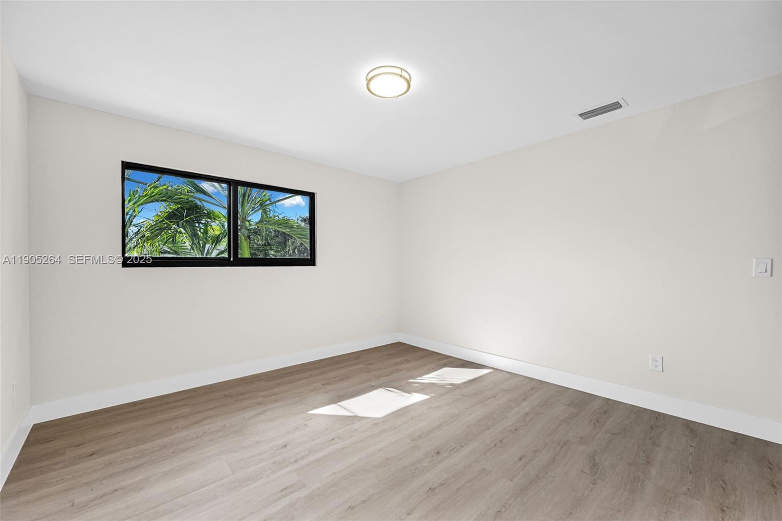 10823 Southwest 147th Court Miami, FL 33196 - Photo 74 of 100 an empty room with wooden floor and window