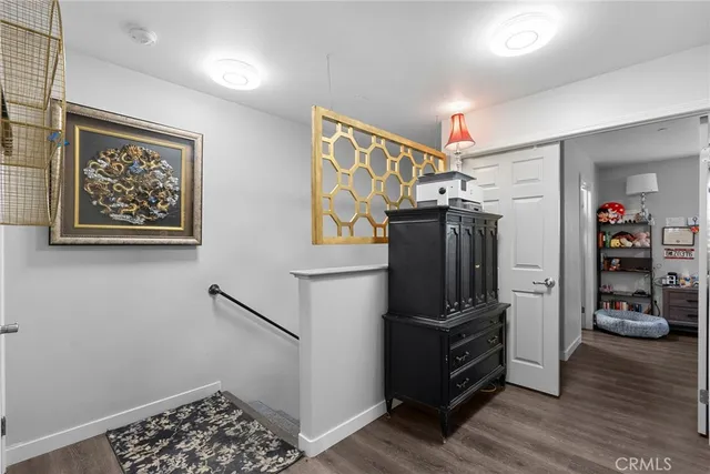a view of a hallway with wooden floor and closet