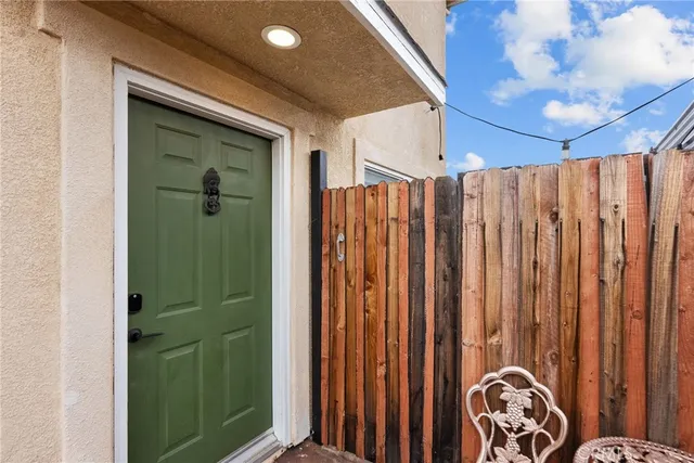 a view of a hallway with wooden floor and a bathroom