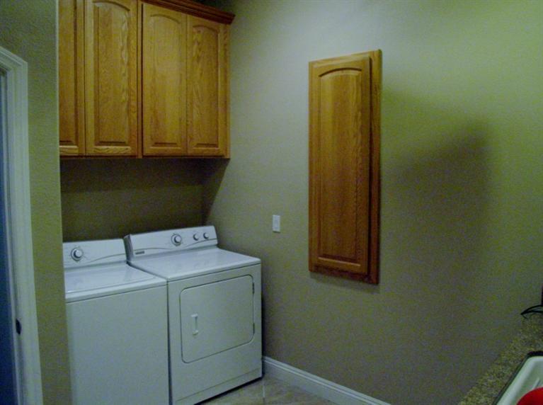 2416 Rodeo Street Selma, CA 93662 - Photo 85 of 99 Inside laundry with ironing board and cabinets
