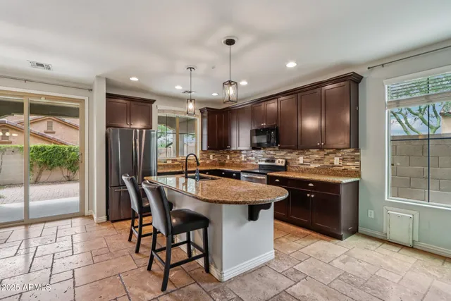 a kitchen with granite countertop a sink a counter top space appliances and cabinets