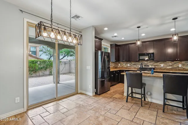 a kitchen with stainless steel appliances granite countertop a refrigerator and a stove top oven