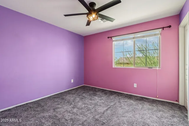 a view of a livingroom with a ceiling fan and window