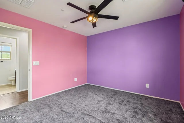 an empty room with a ceiling fan and window