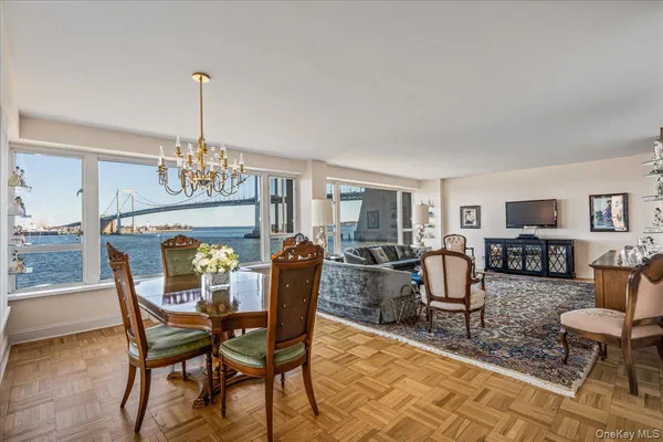 a dining room with furniture a chandelier and wooden floor