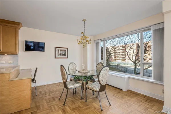 a dining room with furniture a chandelier and window
