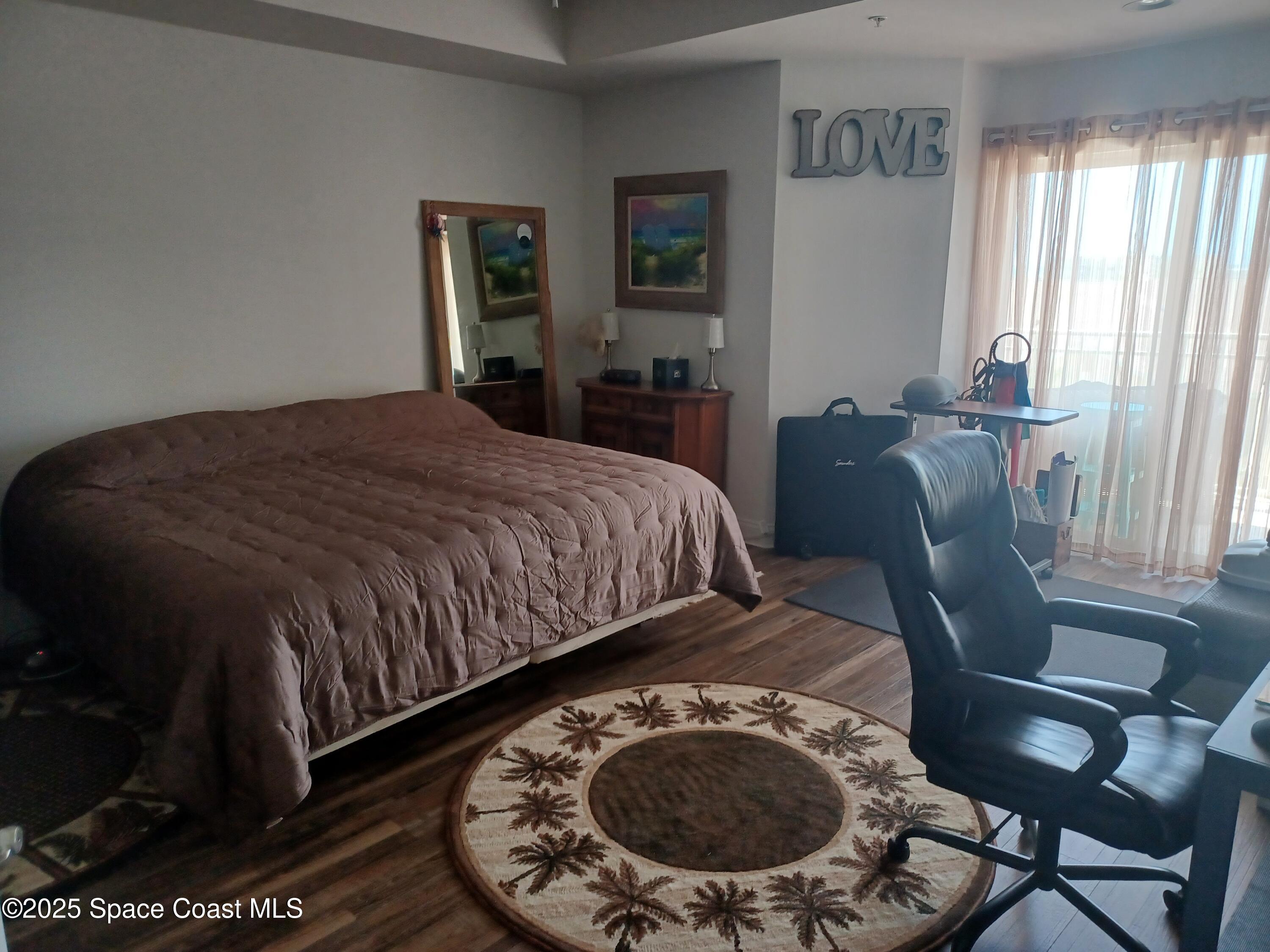 105 Pulsipher Avenue, Unit 403 Cocoa Beach, FL 32931 - Photo 11 of 15 a bed sitting in a bedroom next to a window