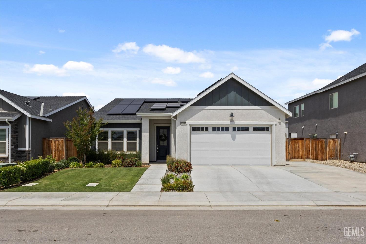 Undisclosed Address Shafter, CA 93263 - Photo 2 of 43 a view of a white house with large windows and a small yard