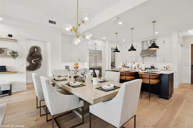 a view of a dining room with furniture a chandelier and wooden floor