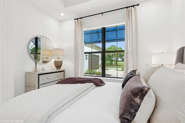 a bed sitting in a bedroom next to a lamp