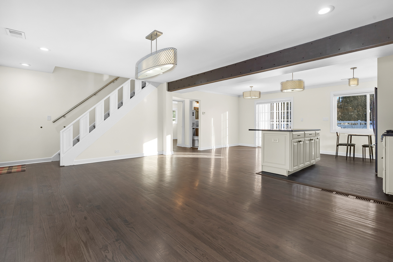3225 Illinois Road Wilmette, IL 60091 - Photo 7 of 22 a view of a living room and kitchen with furniture wooden floor and windows