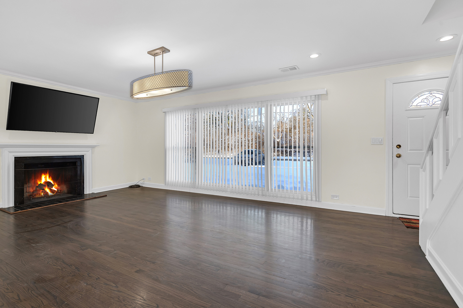 3225 Illinois Road Wilmette, IL 60091 - Photo 8 of 22 a view of an empty room with wooden floor fireplace and a window
