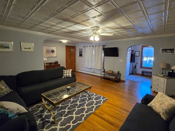 a living room with furniture and a wooden floor
