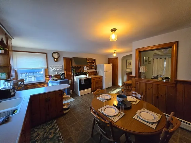 a open dining room with furniture a window and kitchen view