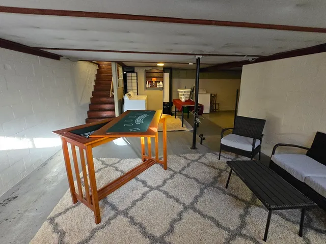 a view of a livingroom with lounge chair and a large window