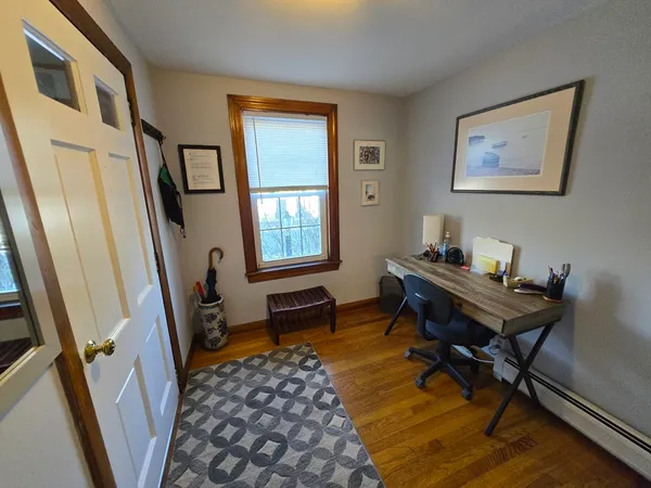 a view of a workspace with furniture and a window