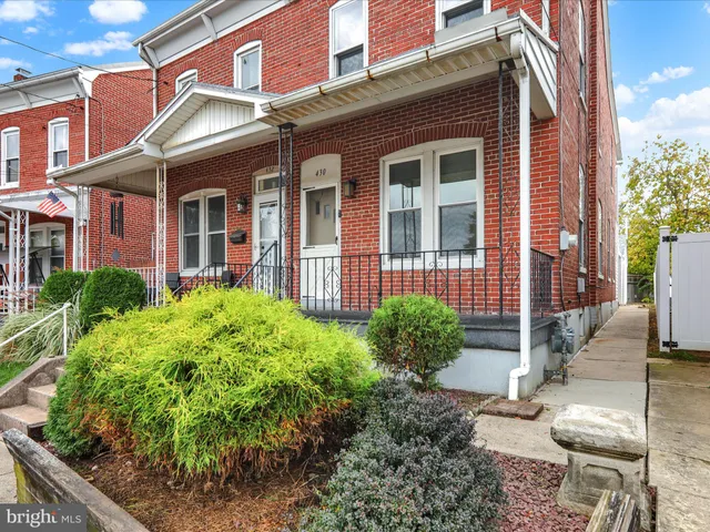 front view of a brick house with a yard