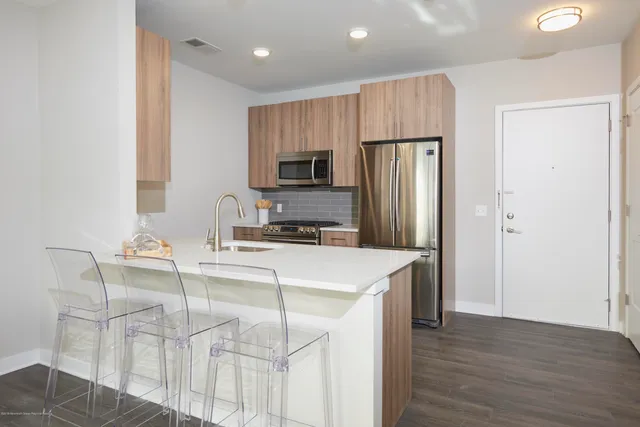 a kitchen with kitchen island a refrigerator stove and microwave