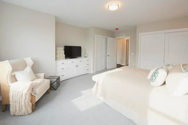 a spacious bedroom with a bed and a flat screen tv