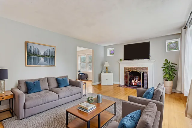 a living room with furniture a flat screen tv and a fireplace