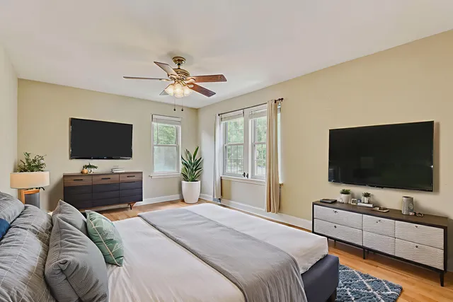 a view of a room with wooden floor and ceiling fan