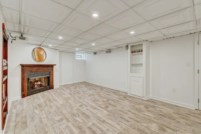 a view of an empty room with a window and a kitchen