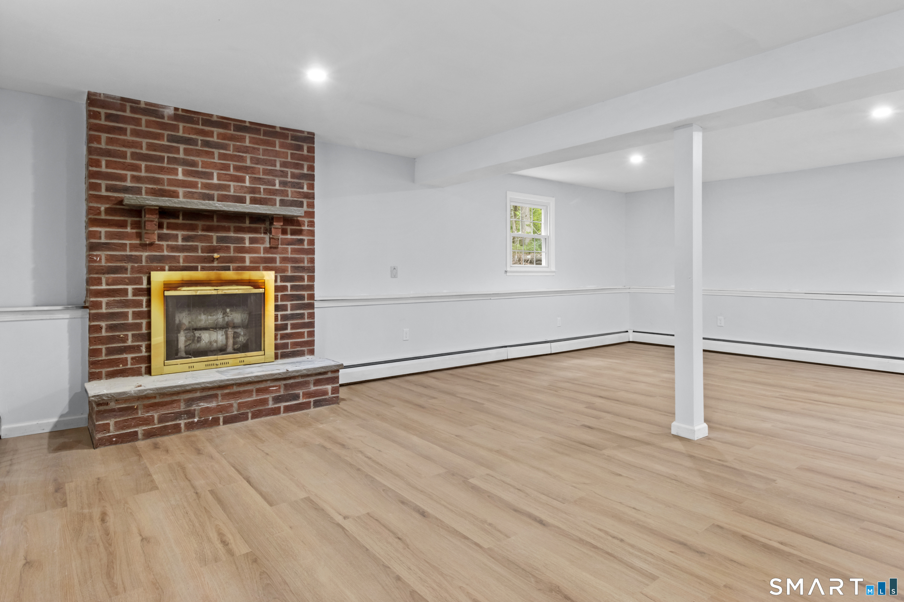 20 Quiet Woods Road East Hampton, CT 06424 - Photo 25 of 40 an empty room with wooden floor a fireplace and windows
