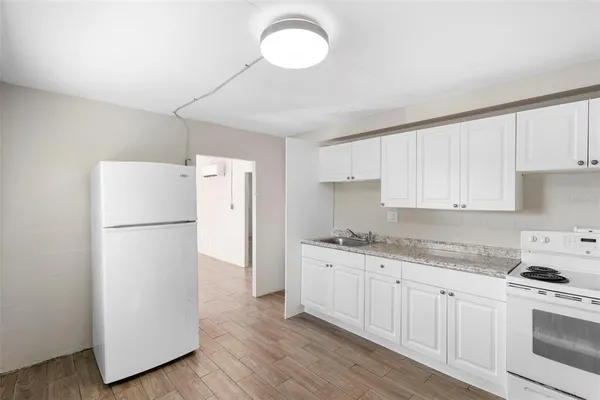 a kitchen with granite countertop white cabinets and white appliances