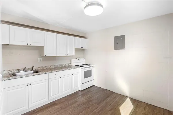a kitchen with granite countertop white cabinets and white appliances