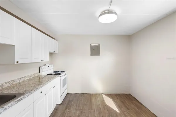 a kitchen with granite countertop white cabinets and white appliances