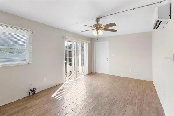 a view of an empty room with a window and wooden floor