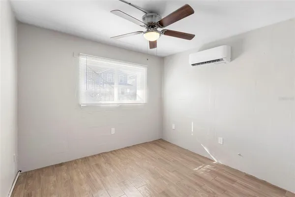 an empty room with a window and a ceiling fan