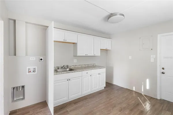 a kitchen with granite countertop a sink and cabinets