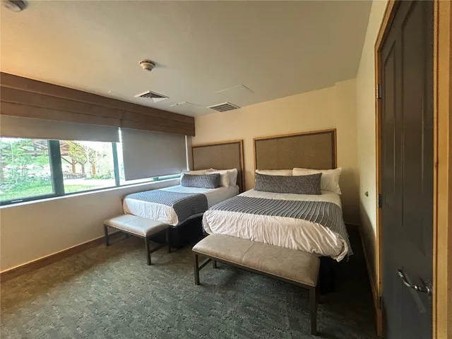 a bedroom with two beds and a large window