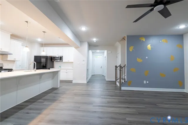 a view of kitchen with stainless steel appliances refrigerator stove microwave and cabinets