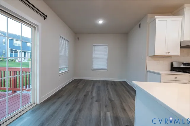 a kitchen with a wooden floor and white cabinets