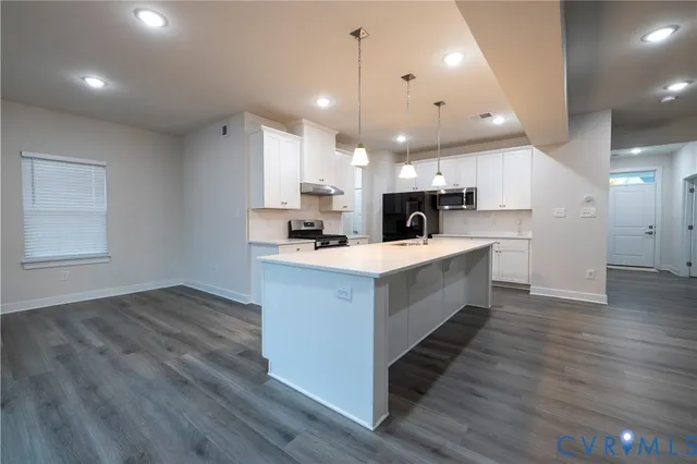 a view of a kitchen with wooden floor and electronic appliances