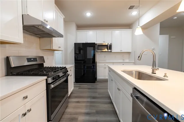 a view of a kitchen with a sink and refrigerator
