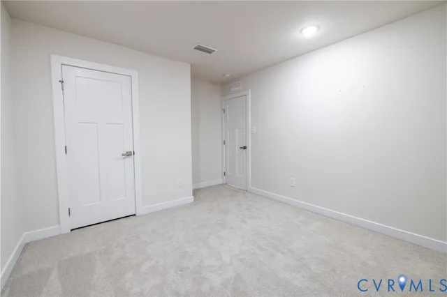 an empty room with ceiling fan and window