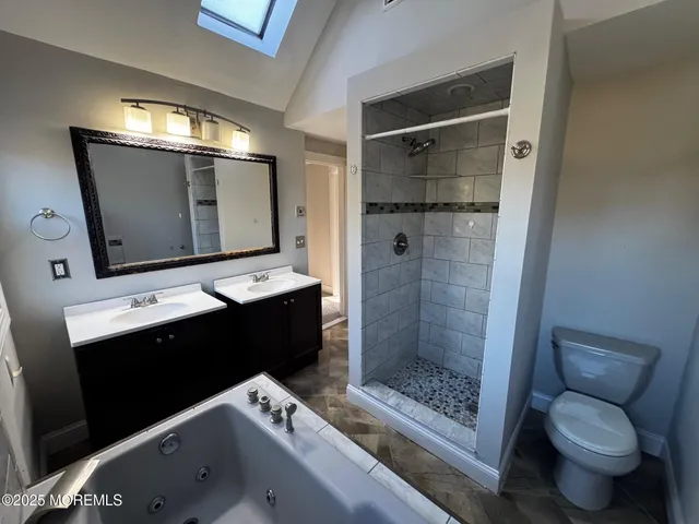 a bathroom with a tub sink and mirror