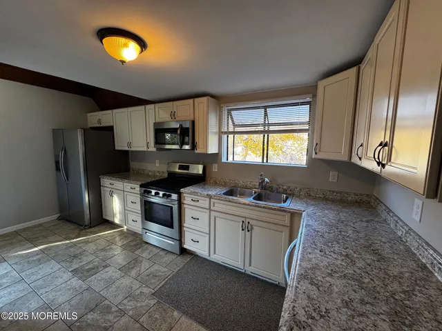 a kitchen with stainless steel appliances granite countertop a stove a sink dishwasher and a refrigerator