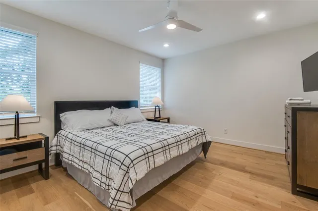 a spacious bedroom with a bed and a lamp