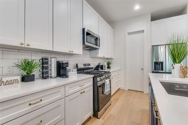 a kitchen with granite countertop white cabinets and white appliances