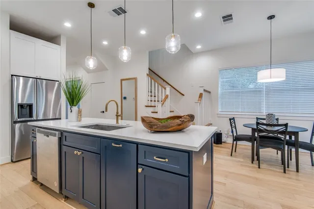 a kitchen with kitchen island a sink dining table and chairs