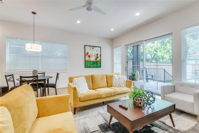 a living room with furniture kitchen view and a large window