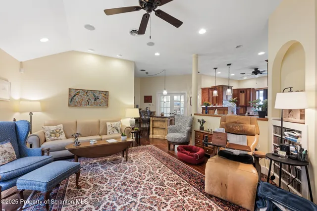 a living room with lots of furniture and a ceiling fan